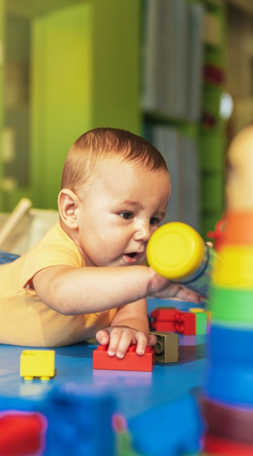 happy-baby-playing-with-toy-blocks-in-the-kindergarten-.jpg